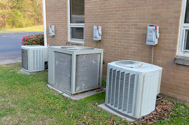 multiple air conditioner units next to commercia